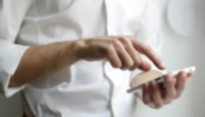 Person in a white shirt using a smartphone