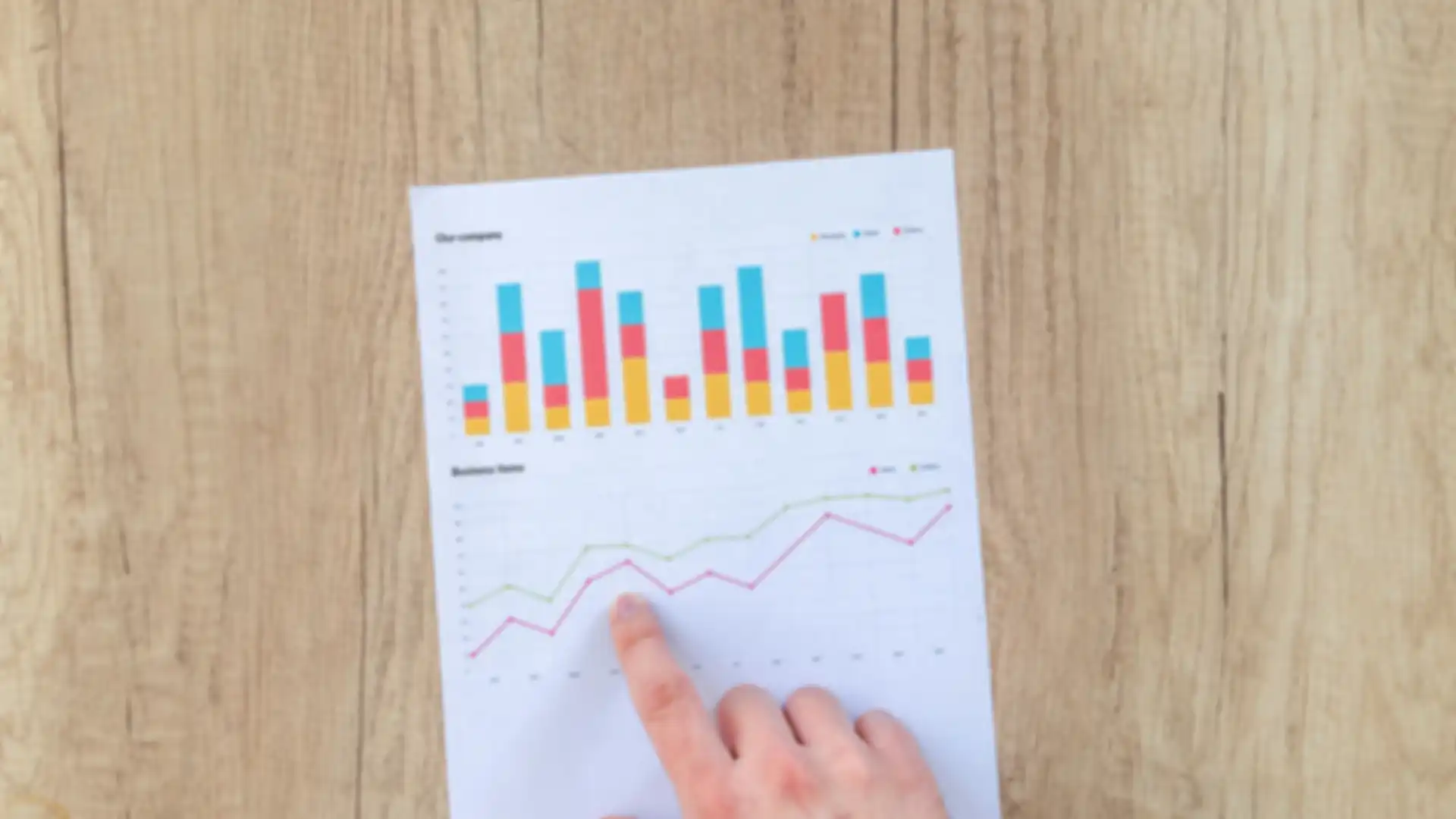 Person pointing at a document containing multiple charts